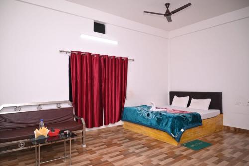 1 dormitorio con cama y cortina roja en Chang Ghar Resort en Kāziranga