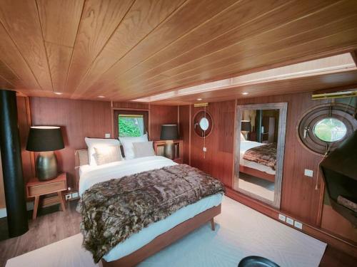 1 dormitorio con 1 cama grande en un barco en Peniche relaxant, en Sèvres