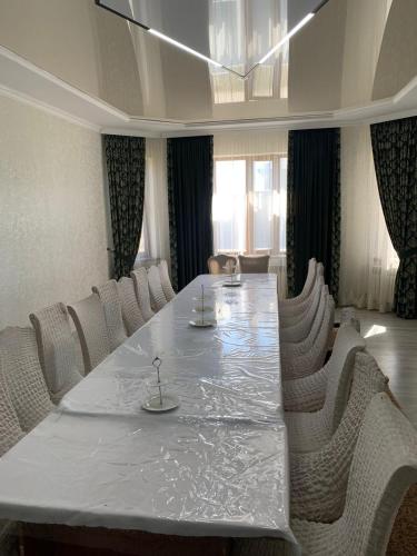 einen Konferenzraum mit einem großen weißen Tisch und Stühlen in der Unterkunft Гостевой Домик Жайлау in Taras