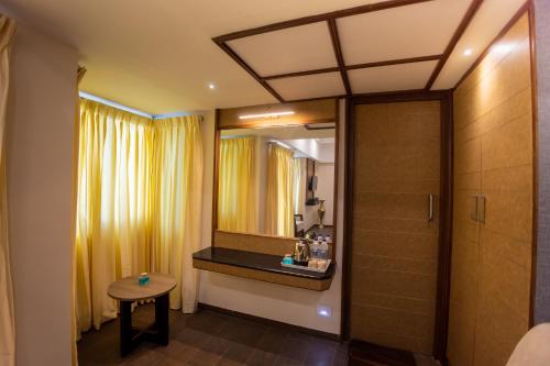 a bathroom with a shower and a mirror at Hotel Grand Sabarees in Madurai