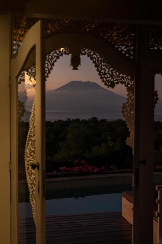 a view of a mountain through an open door at Mambo Hill Resort in Nusa Penida