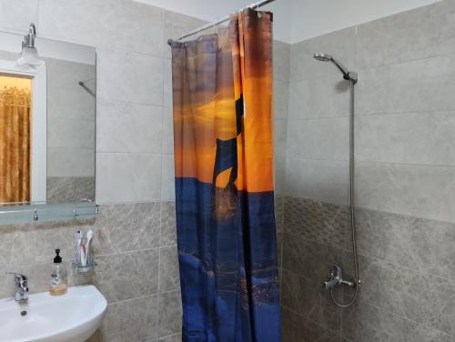 a shower curtain in a bathroom with a sink at Beautiful 1-Bed House in Korce in Korçë