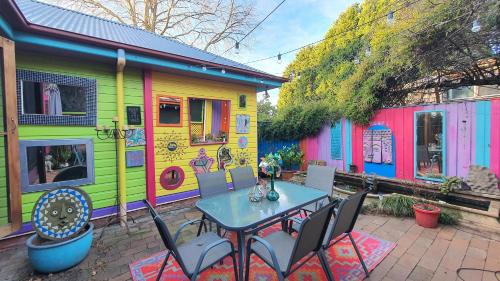 a table and chairs in front of a colorful house at Bowral Road Art Gallery Bed and Breakfast in Mittagong