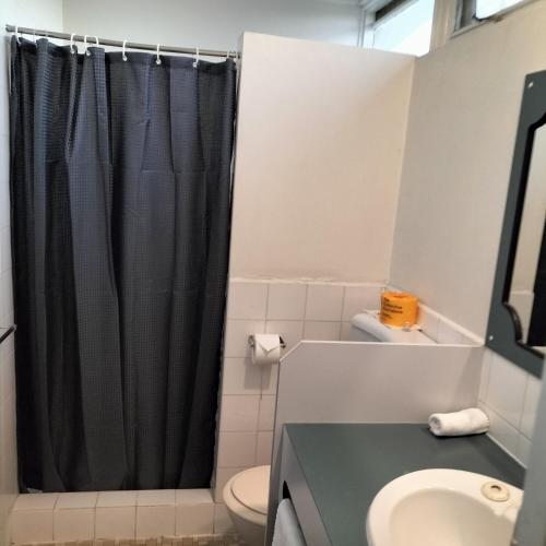 a bathroom with a black shower curtain and a sink at Wangaratta Motor Inn in Wangaratta