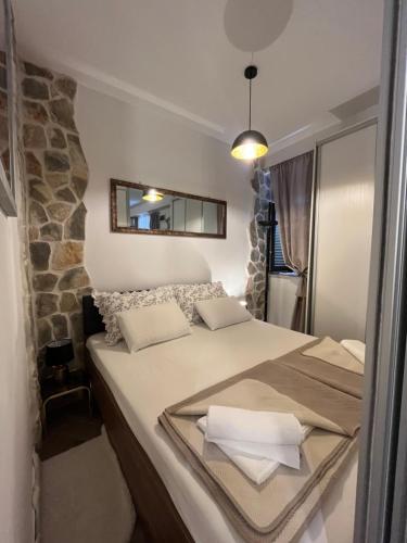 Madona di Sinj في سيني: غرفة نوم بسريرين ومرآة على الحائط