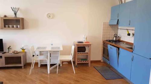 een keuken met een kleine tafel en een keuken met blauwe kasten bij Bilocale sull'acqua al Porto Antico in Genua