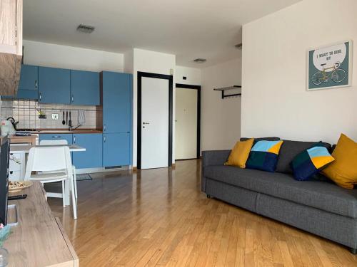 sala de estar con sofá gris y cocina en Bilocale sull'acqua al Porto Antico, en Génova