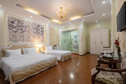 a bedroom with two beds and a chandelier at My Moon Hotel Hanoi in Hanoi