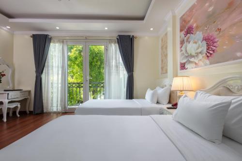 a large bedroom with two beds and a window at My Moon Hotel Hanoi in Hanoi