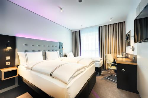 a hotel room with a large bed and a desk at Premier Inn Darmstadt City Centre in Darmstadt