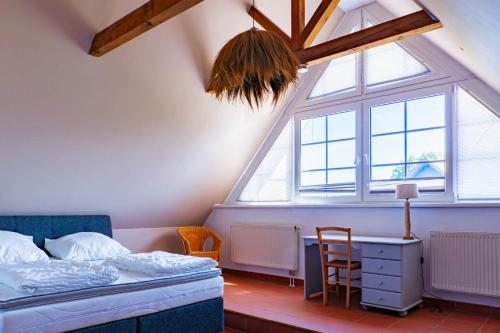Schlafzimmer mit einem Bett, einem Fenster und einem Schreibtisch in der Unterkunft Ferienhausanlage Sonne in Dranske