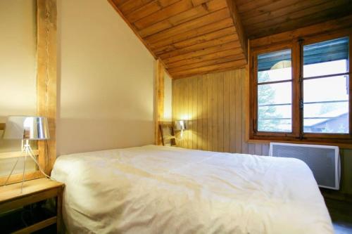 une chambre avec un lit blanc et une fenêtre dans l'établissement Appartement dans maison de pays pour 5 personnes, à Chamonix-Mont-Blanc