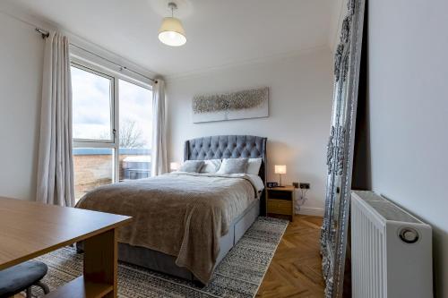 um quarto com uma cama e uma grande janela em Pass the Keys Exquisite Penthouse Private Jacuzzi and Terrace em Birmingham