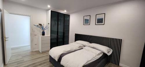 a bedroom with a bed with a black headboard at Durres City Apartment, City center & close to the beach in Durrës