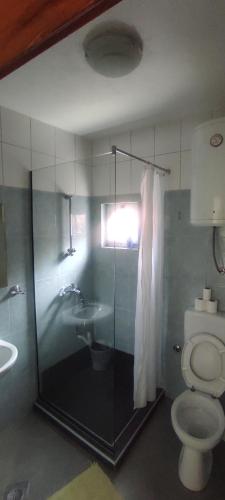 a bathroom with a shower and a toilet and a sink at Hotel & Rooms Lombrelle in Mostar