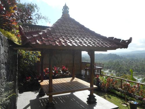 a wooden gazebo with a roof on a balcony at Villa Dukuh in Selat