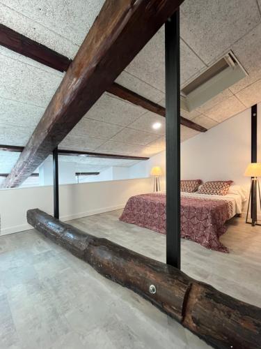 een grote balkenplafond in een kamer met een bed bij Loft Appartement Vacances in Pinet