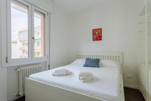 a bedroom with a white bed with towels on it at Yourbanflat Manga in Padova