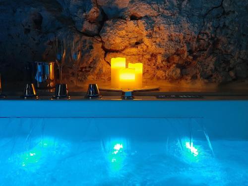 una candela seduta su un tavolo accanto alla piscina di GB Grotta Bianca a Ostuni