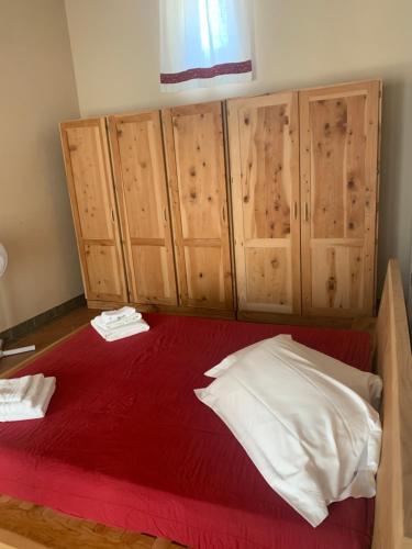 a bedroom with a red bed with wooden cabinets at Fattoria Le Fonti in Poggibonsi