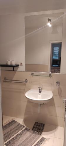 a bathroom with a white sink and a mirror at Hotel & Rooms Lombrelle in Mostar