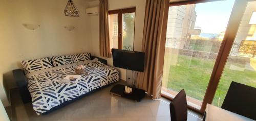 een woonkamer met een zebraprint bank en een televisie bij Miramar 16A in Lozenets
