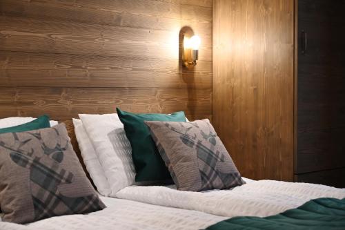 a bedroom with a bed with green and white pillows at Hotel Derby in Folgarida