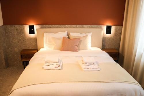 a bedroom with a large white bed with towels on it at Maison d’Arnaud in Ghent