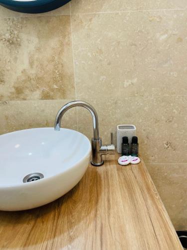 a white sink on a wooden counter in a bathroom at DXN Luxury Studio in Năvodari