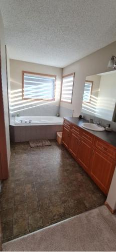 a bathroom with a tub and a sink at Spacious comfortable Air-Conditioned. Near airport! in Calgary