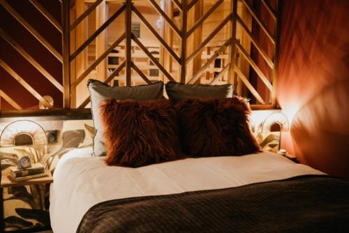 um quarto com uma cama grande e uma parede de madeira em chambre d'hôte doux moment spa privatif em Maresches