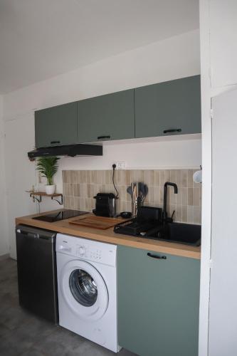 une cuisine avec une machine à laver et un évier dans l'établissement Studio rénové centre ville, clim et terrasse, à Montpellier