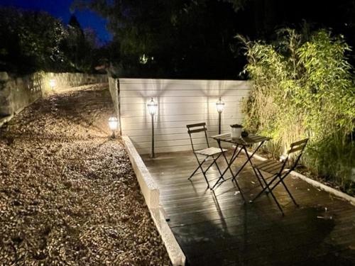 eine Terrasse mit 2 Stühlen und einem Tisch mit 2 Leuchten in der Unterkunft chambre d'hôte doux moment spa privatif in Maresches