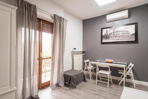 a living room with a table and chairs and a window at Magenta Collection Terrione 25 in Rome