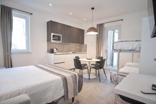 une chambre d'hôtel avec un lit, une table et des chaises dans l'établissement Casa Maluna, à La Spezia