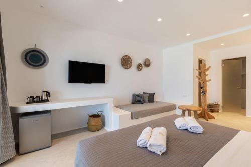 a bedroom with a bed and a tv on the wall at Sunset Hill Suites in Mýkonos City
