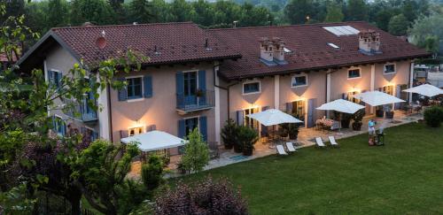 a large building with umbrellas in a yard at Cascina Arcangelo Raffaele in Verduno