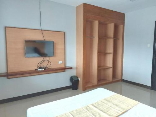 1 dormitorio con 1 cama y TV en la pared en Villa Tomasa 2, Panglao en Panglao City