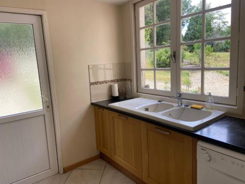 a bathroom with a sink and two windows at Mas des Maje in Boisredon