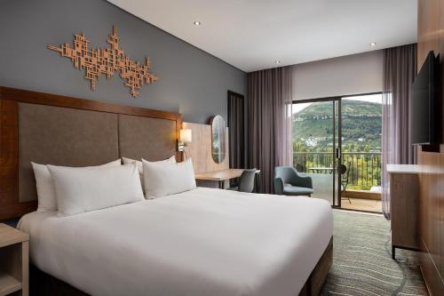 a bedroom with a large white bed in a room at Protea Hotel by Marriott Clarens in Clarens