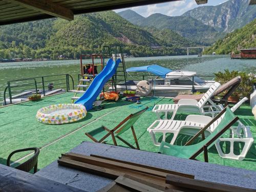 un gruppo di sedie e un parco giochi su un lago di Splav Drina-Višegrad a Višegrad