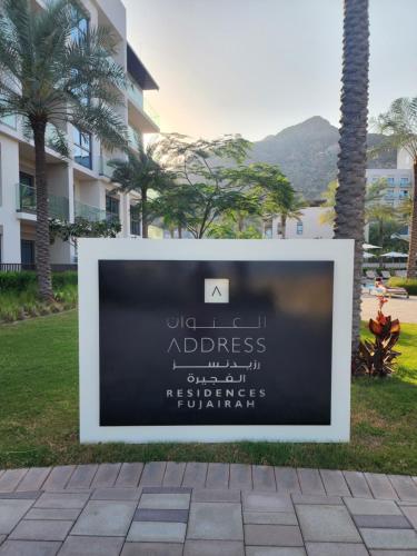 a sign on a sidewalk in front of a building at Address Beach Resort Fujairah Apartment 2 Bed Rooms and Small Bed Room - Ground Floor 3011 in Al Aqah