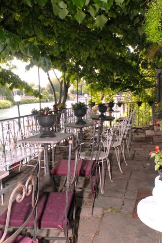 a row of tables and chairs under a tree at Villa Fiorita in Monfalcone