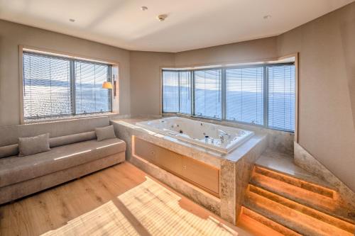 a large bath tub in a room with windows at Kolin Hotel Spa & Convention Center in Canakkale