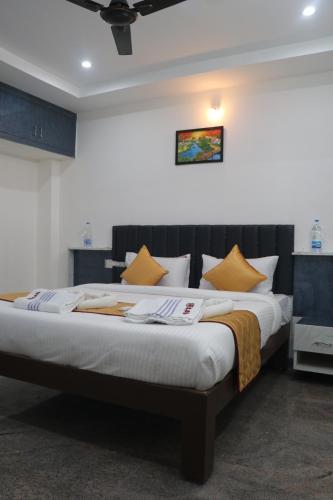 a bedroom with a large bed with yellow pillows at Leo Home Stay in Tirupati