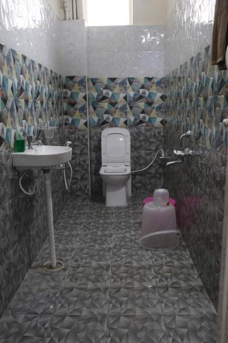 La salle de bains est pourvue de toilettes et d'un lavabo. dans l'établissement Leo Home Stay, à Tirupati