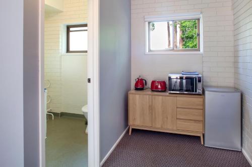a kitchen with a counter with a microwave and a window at Treetops Silvan Valley Lodge - suite 3 in Silvan