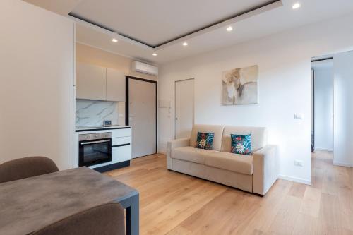 a living room with a couch and a kitchen at Milan Retreats in Milan