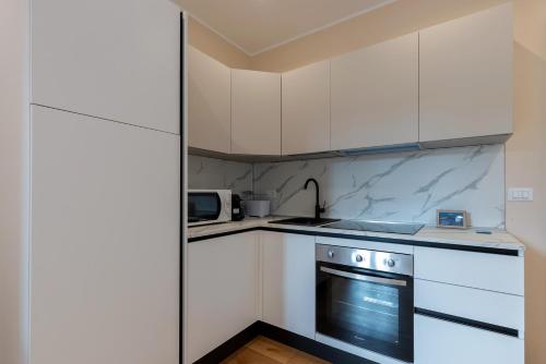 a kitchen with white cabinets and a stove at Milan Retreats in Milan