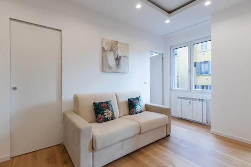 a white living room with a couch and a window at Milan Retreats in Milan